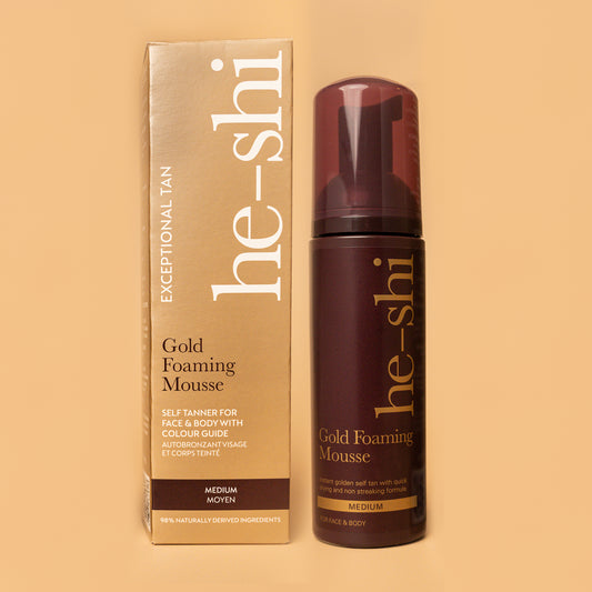 Image of He-Shi Gold Foaming Mousse bottle and outer box on a pale gold background.