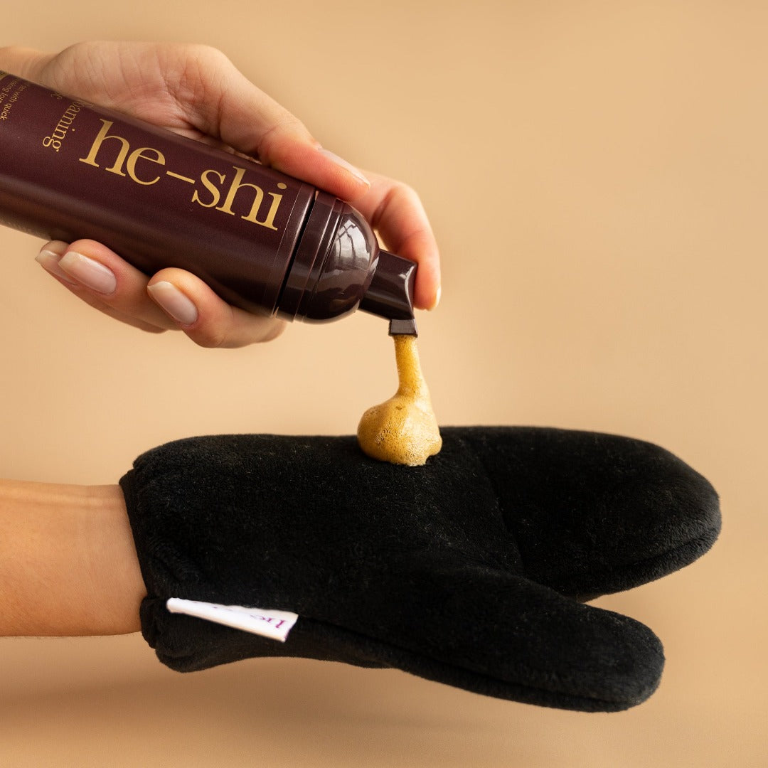 he-shi golden mousse being pumped out and foaming onto a black velvet tanning mitt